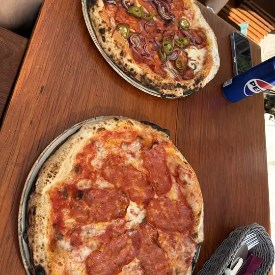Dwie pizze na drewnianym stole